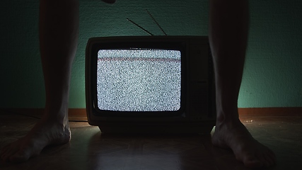 Image showing Man sitting on old television