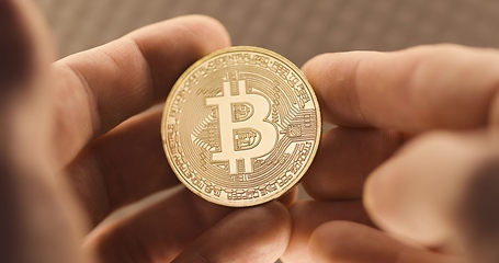 Image showing Inspecting Physical bitcoin held in hands closeup