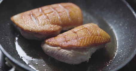 Image showing Roast duck breast in frying pen closeup footage