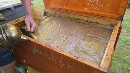 Image showing Opening up a beehive with smoke