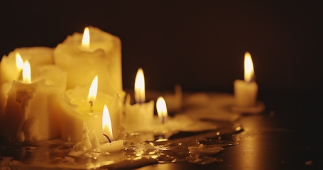 Image showing Candles glowing against dark background