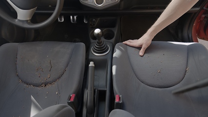 Image showing Man cleaning dirty car interior with vacuum cleaner