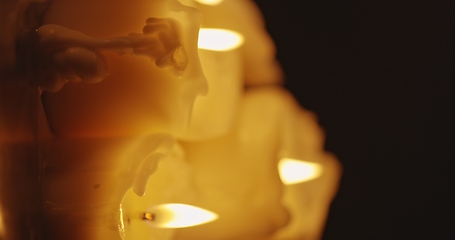 Image showing Vertical video with Candles glowing against dark background