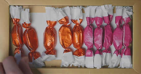 Image showing Man and woman picking out christmas chocolate from box