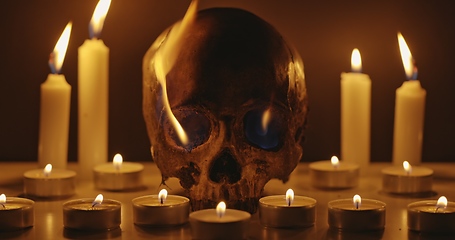 Image showing Candles and human skull in darkness closeup footage