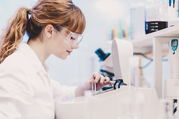 Image showing Attractive young scientist pipetting.