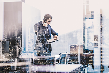 Image showing Businessman talking on mobile phone while looking at wristwatch.