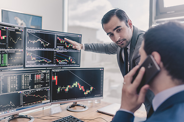 Image showing Stock brokers looking at computer screens, trading online.