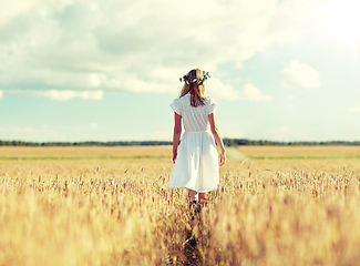 Image showing happy young woman in flower wreath on cereal field