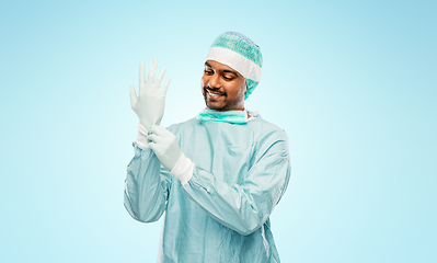 Image showing indian male doctor or surgeon putting glove on