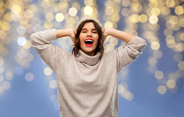 Image showing young woman in winter hat and sweater on christmas