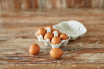 Image showing close up of eggs in cardboard box on wooden table