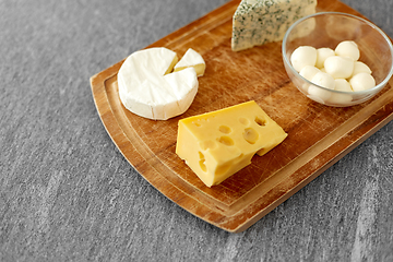 Image showing different kinds of cheese on wooden cutting board