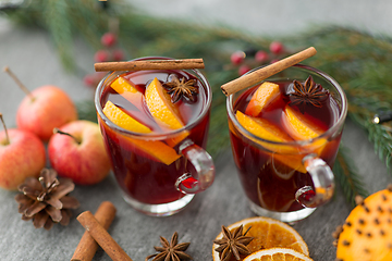 Image showing glass of hot mulled wine, cookies, apples and fir