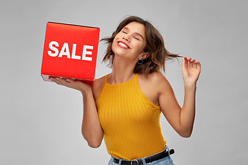 Image showing happy smiling young woman posing with sale sign