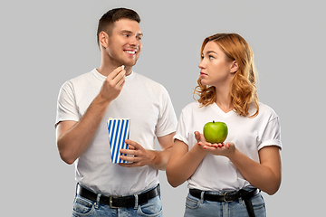 Image showing couple in white t-shirts with popcorn and apple