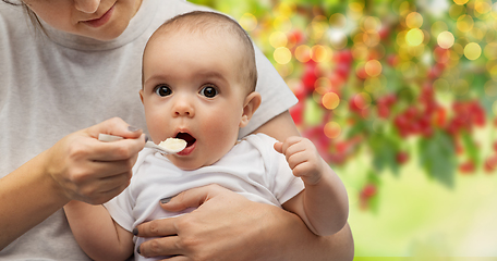 Image showing close up of mother with spoon feeding little baby