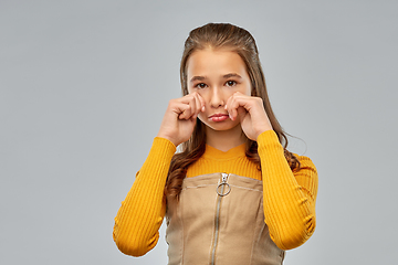 Image showing unhappy crying teenage girl over gray background