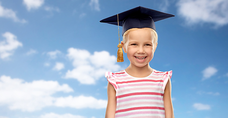 Image showing happy girl in bachelor hat or mortarboard over sky