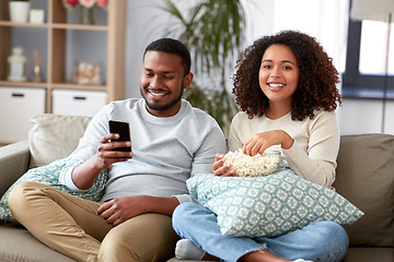 Image showing african couple with popcorn watching tv at home