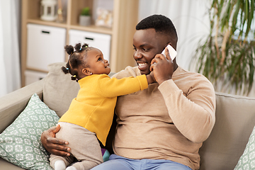 Image showing father with baby at home calling on smartphone