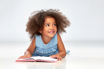 Image showing smiling little african american girl reading book