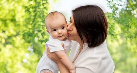 Image showing happy mother kissing little baby daughter