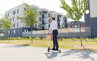 Image showing businessman with takeaway paper bag riding scooter