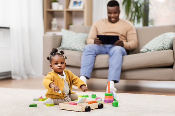 Image showing african baby girl playing with toy blocks at home