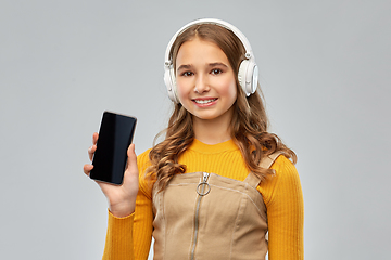 Image showing teenage girl in headphones showing smartphone