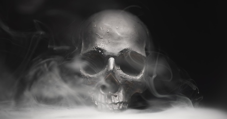 Image showing Black skull in the darkness with smoke and fog