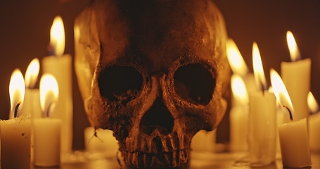 Image showing Candles and human skull in darkness closeup footage