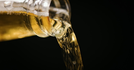 Image showing Beer being poured against dark background with slow movements