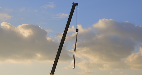 Image showing Industrial construction crane against golden sky