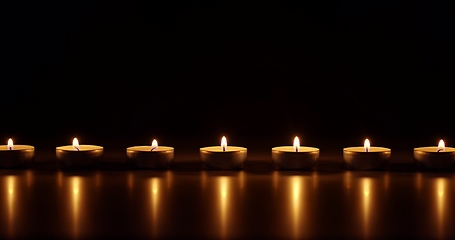 Image showing Candles glowing against dark background