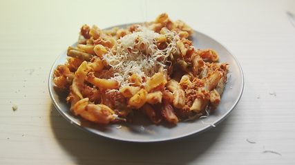 Image showing Cheese topping beiing applied to bowl of pasta
