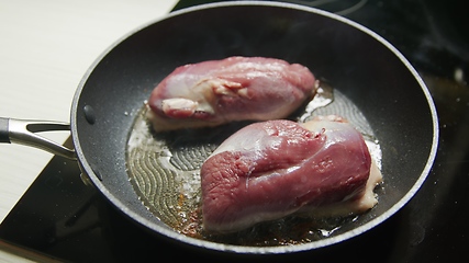 Image showing Roast duck breast in frying pen closeup footage