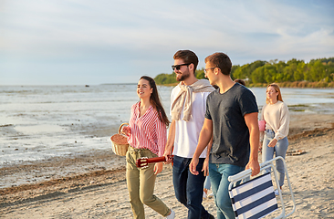 Image showing happy friends walking along summer beach