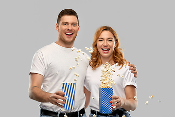 Image showing happy couple in white t-shirts eating popcorn