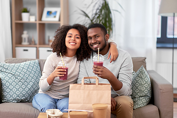 Image showing happy couple with takeaway food and drinks at home