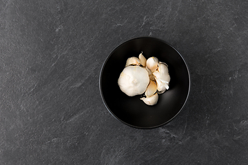 Image showing garlic in bowl on slate stone background