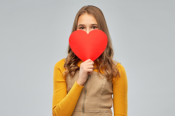 Image showing smiling teenage girl hiding over red heart