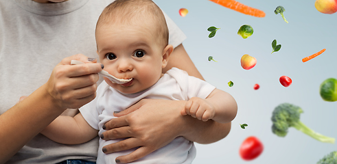 Image showing close up of mother with spoon feeding little baby