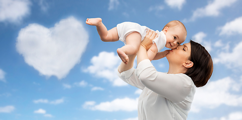 Image showing happy mother kissing little baby daughter