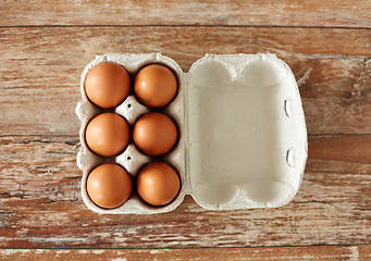 Image showing close up of eggs in cardboard box on wooden table