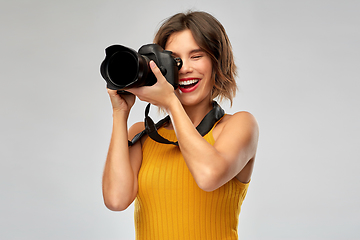 Image showing happy woman photographer with digital camera