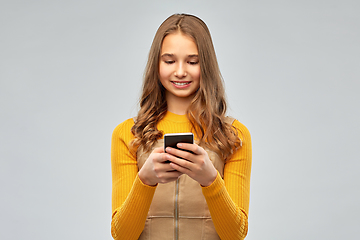 Image showing smiling teenage girl using smartphone