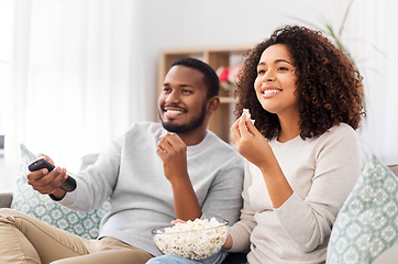 Image showing african couple with popcorn watching tv at home