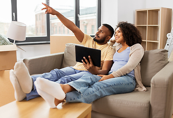 Image showing happy couple with tablet pc computer at new home