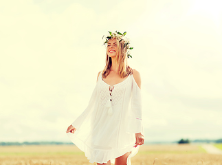 Image showing happy young woman in flower wreath on cereal field